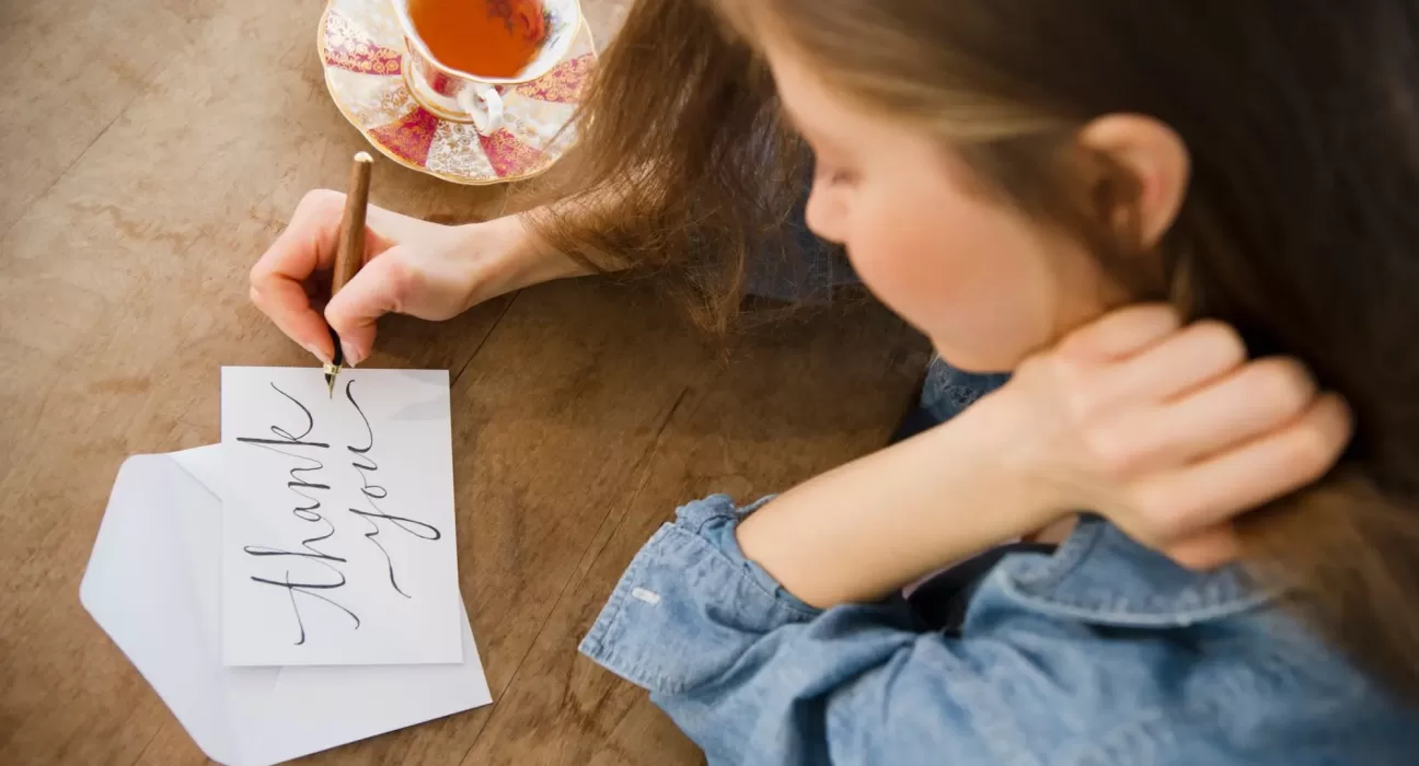 A notebook and pen next to a cup of coffee, ready for a morning 10-minute Gratitude Journaling Benefits practice.