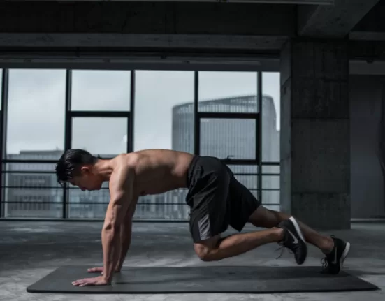 A person doing a simple bodyweight squat in a living room, demonstrating the Beginner Fat Loss Workout without Equipment.