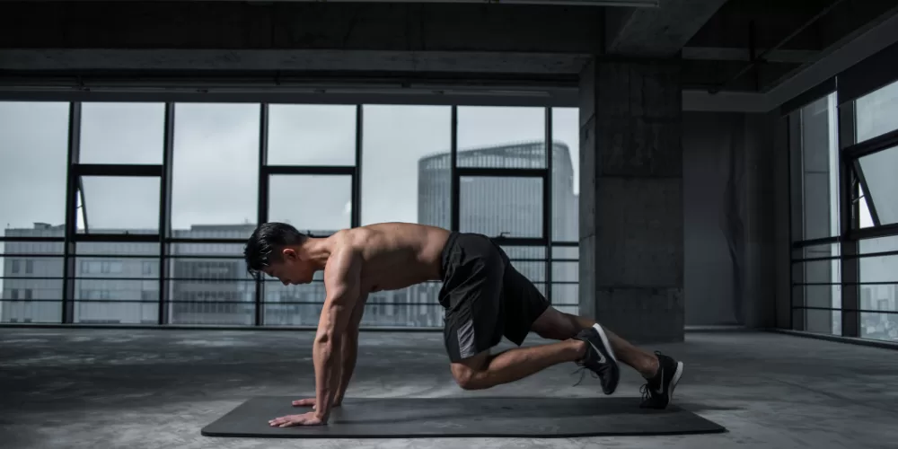 A person doing a simple bodyweight squat in a living room, demonstrating the Beginner Fat Loss Workout without Equipment.