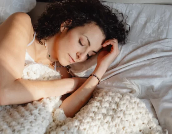 A woman meditating before bed, symbolizing the calming effect of Ayurvedic Sleep Therapy.