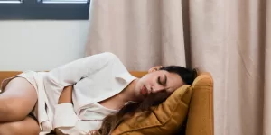 A woman in Child's Pose (Balasana), a recommended yoga posture for relieving Menstrual Pain Period Cramps.