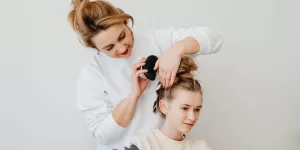 A person performing a warm oil scalp massage using Ayurvedic Hair Care Tips.