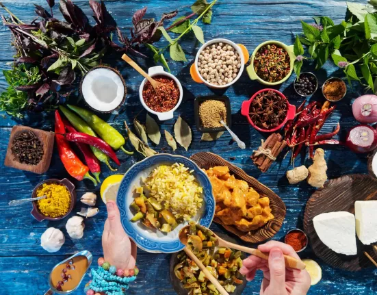 A bowl of Ashwagandha Ksheera Pak (spiced milk) next to Ayurvedic herbs, representing Ayurveda Recipes to Boost Muscles.