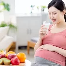 A mother gently massaging her baby or eating a nutritious Laddoo, representing Pregnancy Postpartum Care Nutrition.