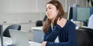 A person performing a simple chest-opening stretch, a key part of the Posture Correction Guide for Desk Workers.