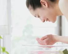 A person performing oil pulling with coconut oil, illustrating an Ayurvedic Morning Routine
