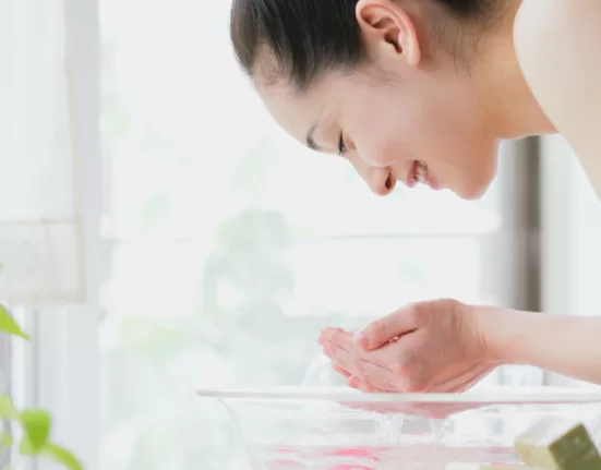 A person performing oil pulling with coconut oil, illustrating an Ayurvedic Morning Routine