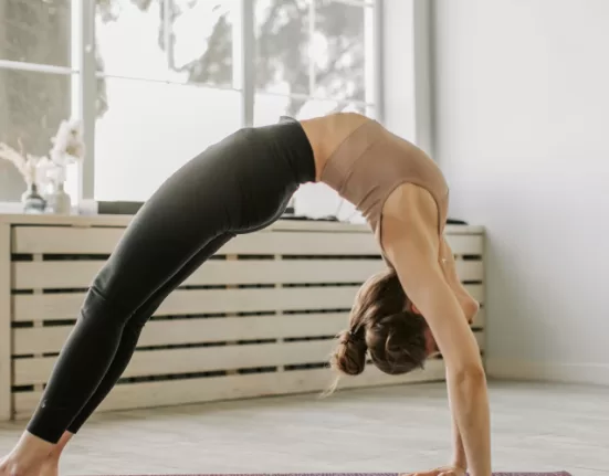 A person demonstrating the seated forward fold, one of the Must-Do Stretches for Tight Hamstrings.