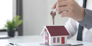 A "SOLD" sign with a happy couple, symbolizing the success of using these Tips for Selling Your Home Fast.