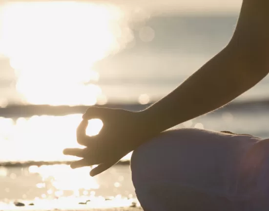 A person sitting in a peaceful meditative pose, representing the core Benefits of Daily Meditation.