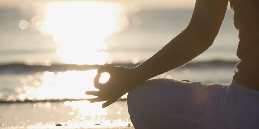 A person sitting in a peaceful meditative pose, representing the core Benefits of Daily Meditation.