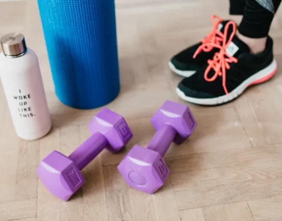 A woman demonstrating the Hundred, a fundamental move in Pilates Exercises for Beginners.