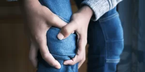 A person gently moving their knee, symbolizing relief from Ayurvedic Treatments for Joint Pain.